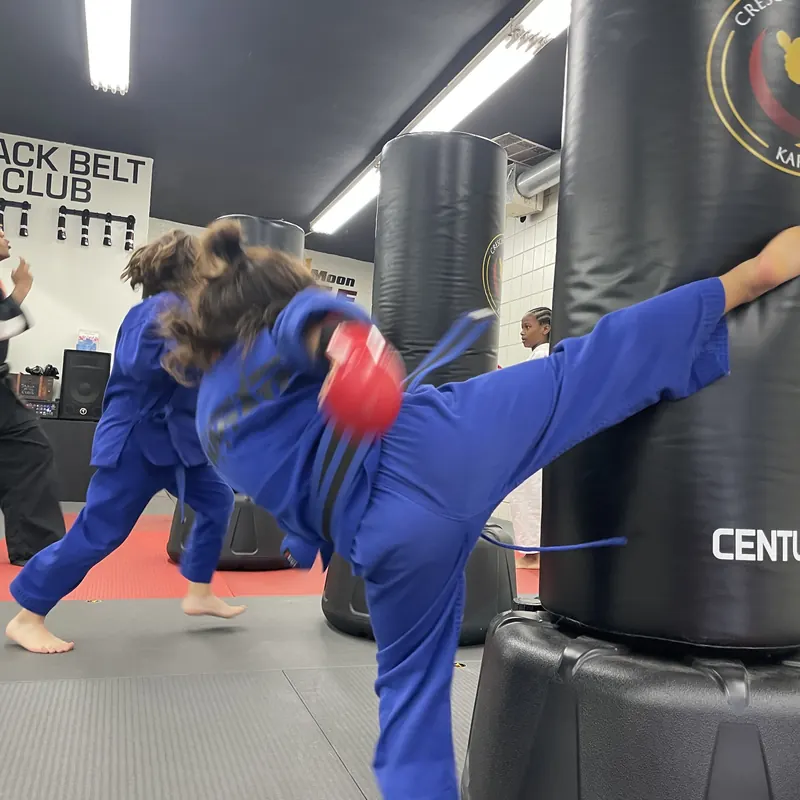 A student practicing kicks on a training bag