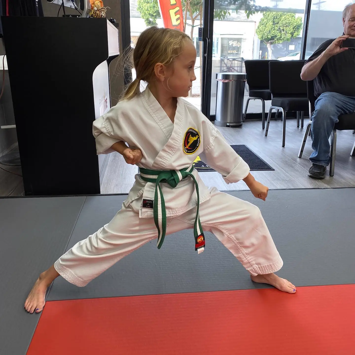 A student holding a karate stance on the training floor